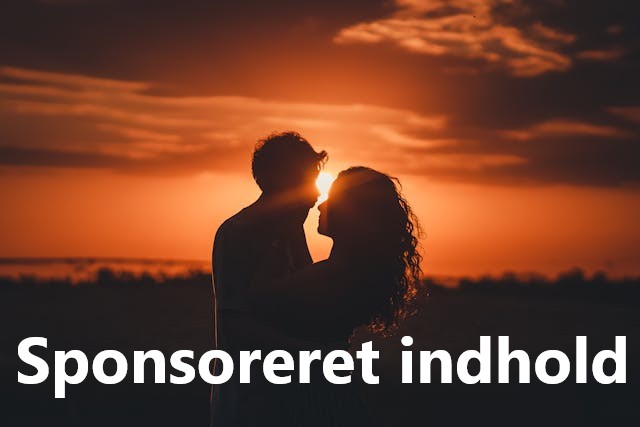 Par i silhuet foran solnedgang kysser hinanden